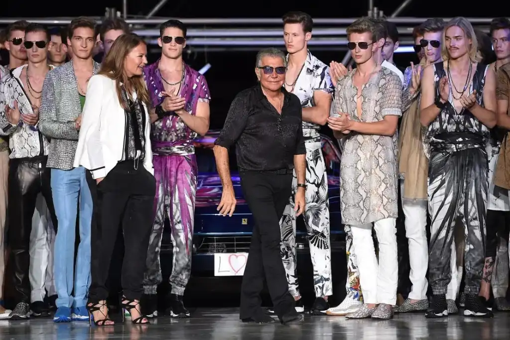 Rodeado de modelos con los típicos florales y estampados animales de Cavalli | Qué Onda
